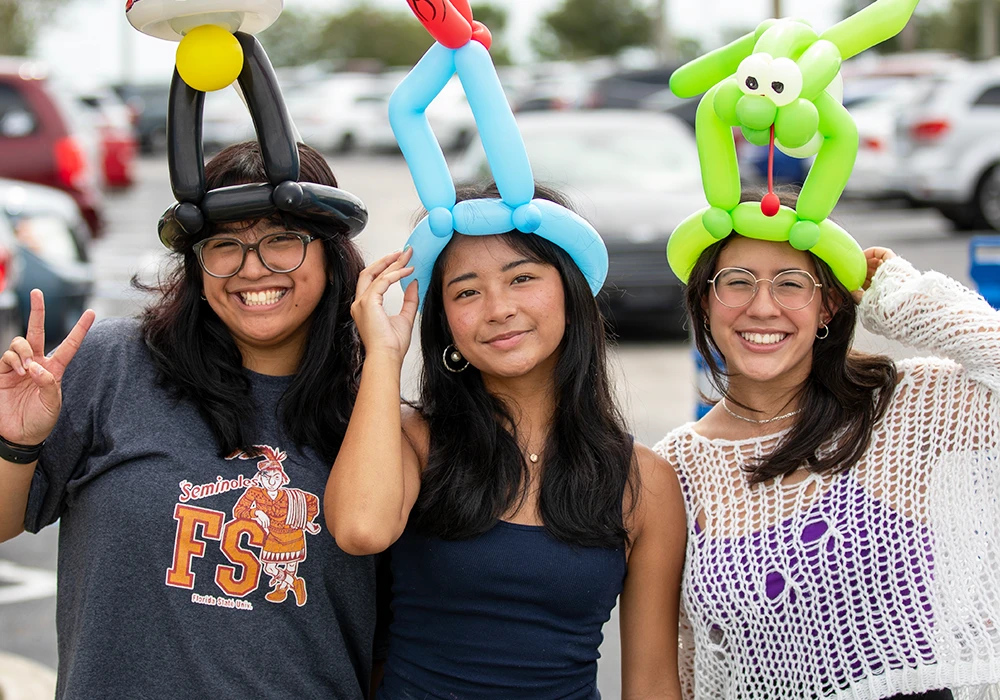 Students celebrating wearing balloon animal hats.